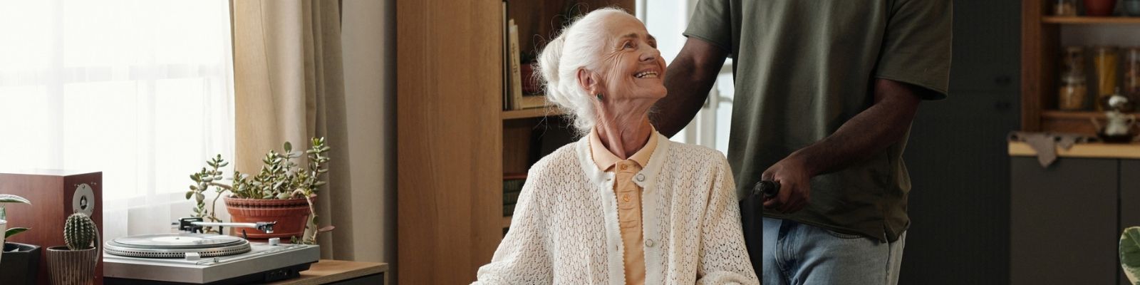 Woman talking with man in assisted living apartment.